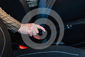 Close-up of female hand tightening seat belt inside her car.