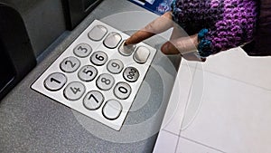 Close up of a female hand using an ATM banking machine