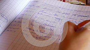 Close up of a female hand writing with a pen in a journal