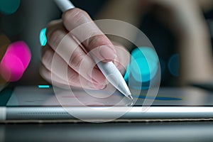 Close up of female hand writing with white pen on computer tablet