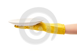 Close up of female hand in yellow protective rubber glove holding clean white plate