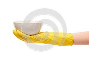 Close up of female hand in yellow protective rubber glove holding clean white plate