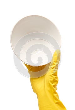 Close up of female hand in yellow protective rubber glove holding clean white plate