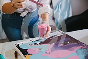 Close-up female hands creates a picture with acrylics