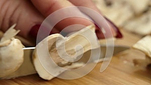 Close-up of the female hands cutting fresh champignons in slow motion