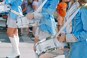 Close-up of female hands drummers are knocking in the drum of their sticks. Majorettes in the parade