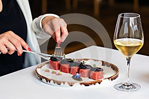 Close up of female hands eating blue fin tuna starter in restaurant