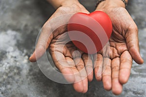 Close up female hands giving red heart as heart donor. Valentine day of love concept. Medical ventilator and heart donator charity photo