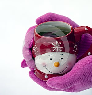 Close-up of female hands on gloves holding tea cup