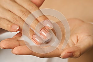 Close up of female hands holding, applying gentle foam facial cleanser