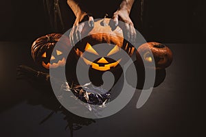 Close-up of female hands holding a halloween pumpkin in the dark