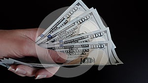 Close-up of female hands holding a pack of one hundred dollar bills.The concept of paying for goods and services, getting paid,