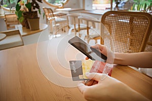 Close up female hands holding smart phone with credit card and choosing to use. using cellphone for digital banking, internet