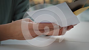 Close-up female hands holds envelopes letters correspondence receive alerts from bank account. Unrecognizable woman