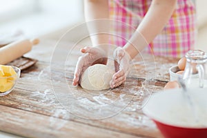 Close up of female hands kneading dough at home