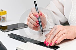 Close-up of female hands with laptop, smartphone and notebook