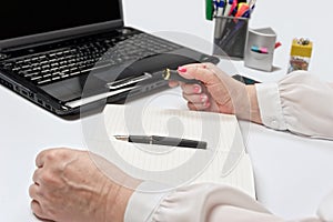 Close-up of female hands with laptop, smartphone and notebook