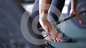 Close-up female hands lifting heavy barbell in gym indoors. Unrecognizable Caucasian sportswoman powerlifting sportive