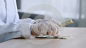 Close-up female hands in medical latex gloves of unrecognizable woman doctor pharmacist scientist in white coat counts