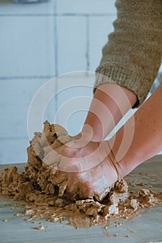 Close-up female hands mixing clay ball before working on a pottery wheel