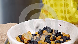 Close-up of female hands mixing multi-colored raisins in a bowl. Making muffins or Easter cakes.