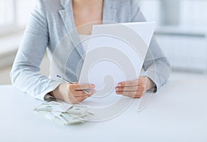 Close up of female hands with money and tax report