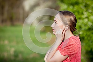 Close-up Of Female Hands Putting Hearing Aid In Ear. Modern digital in the ear hearing aid for deafness and the hard of hearing