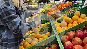 Close up of female hands putting oranges into reusable produce eco bag