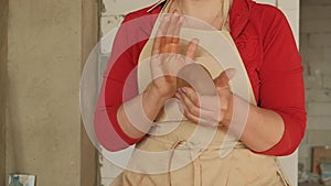 Close-up female hands rolling clay ball before working on a pottery wheel