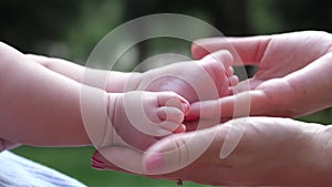 Close-up female hands stroking baby's feet