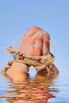 Close up of female hands tied in a rope