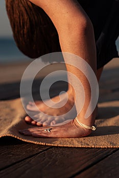 Close up of female hands touching mat, woman practicing yoga uttanasana