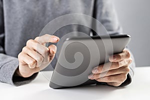 Close-up of female hands touching screen of tablet
