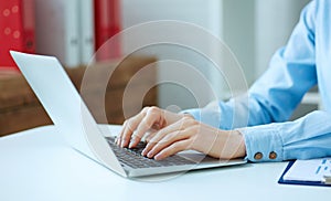 Close up of female hands typing on laptop keyboard.