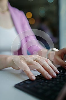 Close-up on female hands typing on laptop keyboard, copy space, vertical