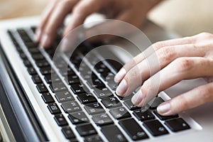 Close-up of female hands typing text on the keyboard of laptop or computer. Manager. photo