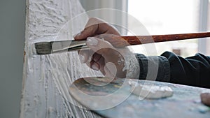 Close-up female hands unknown Caucasian painter artist woman create art minimalistic picture holding palette using white