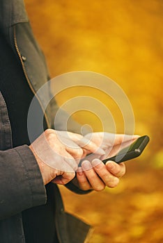 Close up of female hands using mobile phone outdoors