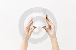 Close up of female hands vertical holds white empty paint tin can with copy space isolated on white background