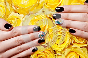Close Up of Female Hands Wearing Bright Polish on Nails and Holding Yellow Roses