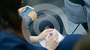 Close up female hands writing notes from seminar on paper notebook. irrl people with notepad