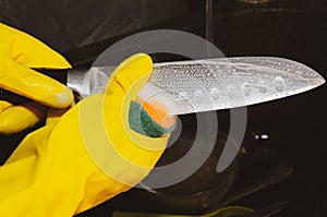 Close up of female hands in yellow protective rubber gloves,