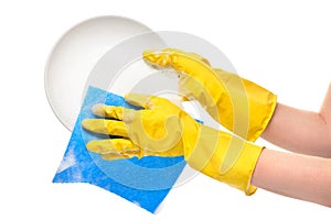 Close up of female hands in yellow protective rubber gloves washing white plate with blue rag