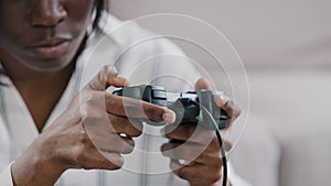 Close-up female hands young concentrated african american woman gamer holding joystick playing video games on console