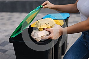 Close-up of female hold two cardboard tray of eggs. Rubbish, egg carton and thowing into recycling bins. Close-up of