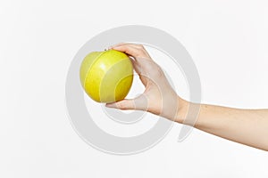 Close up female holds in hand green fresh apple isolated on white background. Proper nutrition, vegetarian food, healthy