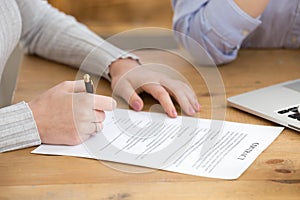 Close up of woman signing work contract in office photo