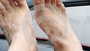 Close-up of female legs with bright nail varnish, pedicure. lie in front of the windshield. it`s raining, car wipers are