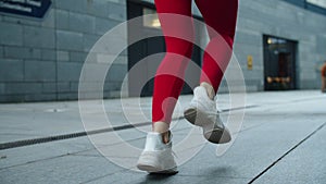 Close up female legs jogging on urban street. Athlete woman legs running outdoor