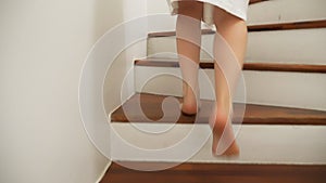 Close-up. female legs rises to the top of a wooden ladder. woman in a dressing gown walks up the steps